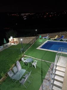 a swimming pool with chairs and a table next to at Areias Village in Vale de Cambra
