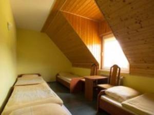 ミチュコフツェにあるNoclegi Pod Bukowinąのベッド3台と窓が備わる客室です。