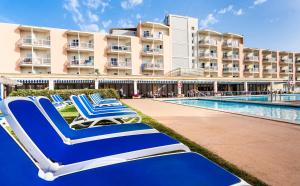 a group of lounge chairs in front of a hotel at Globales Playa Santa Ponsa in Santa Ponsa