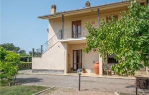 biały dom z balkonem i drzewem w obiekcie 3 Bedroom Cozy Apartment In Capalbio Scalo w mieście Nunziatella