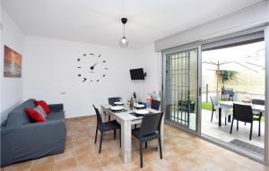 een woonkamer met een tafel en stoelen en een klok bij Lovely Apartment In Anzio With Kitchen in Anzio