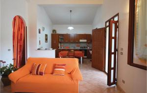 an orange couch in a living room with a kitchen at Casa Nella Prateria in Giarratana