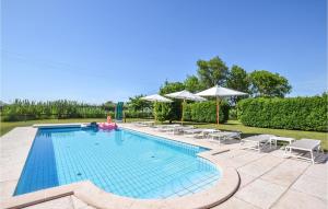 a large swimming pool with chairs and umbrellas at Porta Di Valle 2 in Cavallino-Treporti