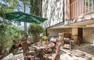 eine Terrasse mit Tisch, Stühlen und Sonnenschirm in der Unterkunft 2 Bedroom Awesome Home In Piediluco in Piediluco