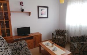 uma sala de estar com duas cadeiras e uma televisão em Beautiful Apartment In Alhama De Murcia With 2 Bedrooms, Wifi And Outdoor Swimming Pool em El Romero