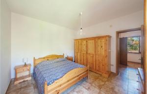 - une chambre avec un lit et une armoire en bois dans l'établissement Ginepro, à Sorso