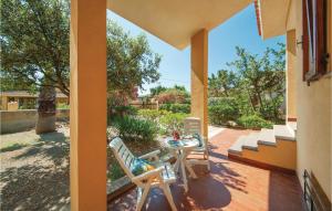 a patio with a table and chairs on a porch at Ginepro in Sorso