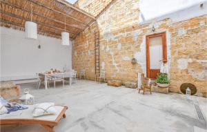 Zimmer mit Ziegelwand, Tisch und Stühlen in der Unterkunft 2 Bedroom Amazing Apartment In Trappeto in Trappeto