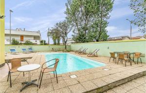 a swimming pool with chairs and tables and a table and chairs at Beautiful Home In Torvaianica With 5 Bedrooms And Outdoor Swimming Pool in Torvaianica