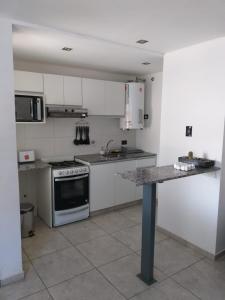 a kitchen with white cabinets and a counter top at Necochea Isor in Godoy Cruz