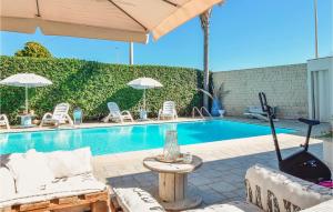einen Pool mit Stühlen, einem Tisch und einem Sonnenschirm in der Unterkunft Villa Calambra in Villaggio Azzurro + 24 Fotos