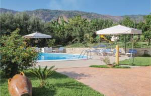 uma piscina com um guarda-sol e cadeiras e uma mesa em Villa Mare em Ioppolo