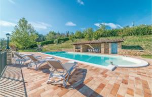 a swimming pool with lounge chairs and a house at Il Vigneto in Brufa