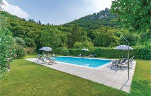 a swimming pool with chairs and umbrellas in a yard at Capre 1 in Garda