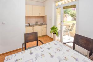a kitchen and dining room with a table and chairs at Apartments Flora in Pakoštane