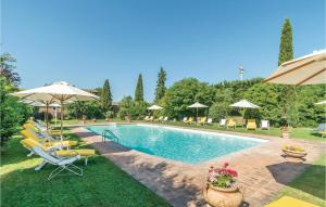 コルトーナにあるNice Apartment In Cortona Ar With Wifiのラウンジチェアとパラソル付きのスイミングプール