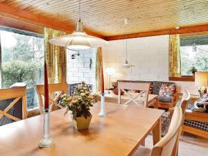 a dining room with a wooden table with flowers on it at Two-Bedroom Holiday home in Asnæs 3 in Asnæs