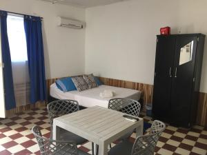 a small room with a bed and a table and chairs at Apartamento Mattos in Taganga