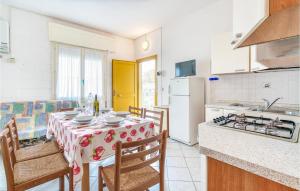 une cuisine avec une table et des chaises ainsi qu'une cuisine avec une cuisinière dans l'établissement Cagialla 4, à Rosolina Mare