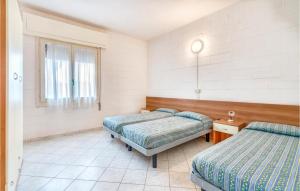 sypialnia z 2 łóżkami i oknem w obiekcie Cagialla 4 w mieście Rosolina Mare
