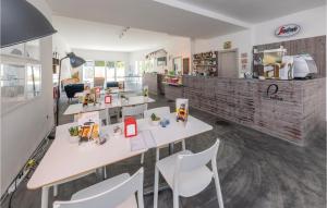 Habitación con mesas y sillas blancas y cocina. en Stunning Apartment In San Cataldo With Kitchenette, en San Cataldo
