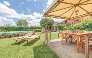 un patio avec une table, des chaises et un parasol dans l'établissement Corte Pasquini, à San Ginese