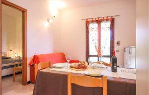 a dining room table with a bottle of wine at 2 Bedroom Amazing Apartment In Costa Rei -Ca- in Monte Nai