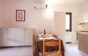 モンテ・ナイにあるAwesome Apartment In Costa Rei -ca- With 2 Bedrooms And Wifiのテーブル、椅子、テーブル席付きのキッチンが備わります。