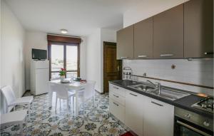 una cocina con fregadero y mesa. en Bilo 1, en Alba Adriatica