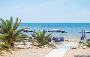 una playa con sillas y sombrillas y el océano en Bilo 1, en Alba Adriatica
