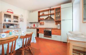 uma cozinha com uma mesa e um frigorífico branco em Beltempo em Luino