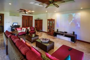 a living room with a couch and a large screen at Baan Phulay Luxury Beachfront Villa in Lipa Noi