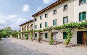 a large white building with vines growing on it at Stunning Apartment In Sacile -pd- With Swimming Pool in Sacile