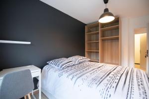 een slaapkamer met een wit bed en een zwarte muur bij Appartement du Vercors - 3 Bedrooms Parking Free Netflix in Fontaine