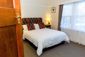 a bedroom with a bed with red pillows and a window at Ashdowns of Dover in Dover