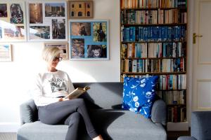 a woman sitting on a chair reading a book at Ashdowns of Dover in Dover