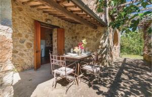 una mesa y sillas en un patio de una casa de piedra en Capanna, en Sovicille