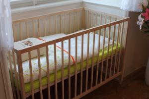 ein Kinderbett mit Matratze in einem Zimmer in der Unterkunft Royal Prague Apartment Celakovskeho Sady in Prag