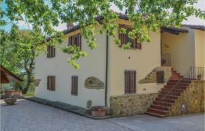 un edificio blanco con escaleras y un árbol en Mattia, en Podere Panzano