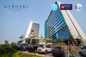 a parking lot with cars parked in front of a building at Avenzel Hotel & Convention Cibubur in Cibubur