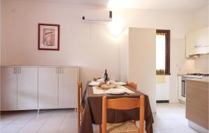 a kitchen with a table with chairs and a tableablish at Awesome Apartment In Costa Rei -Ca- With Wifi in Monte Nai