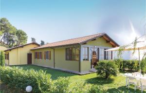 a small yellow house with a green yard at Villa 1 in Corsanico-Bargecchia