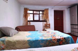 Un dormitorio con una cama con una manta de colores. en Cuzco Central Hostel, en Cusco