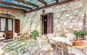 a patio with tables and chairs and a stone wall at Apartment Todi PG 27 in Canonica