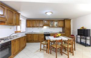 a kitchen with wooden cabinets and a table with chairs at Casa Fiorini in Sassalbo
