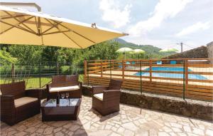 un patio con sillas, una sombrilla y una piscina en Casa Fiorini, en Sassalbo