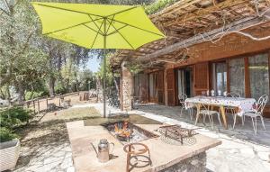 patio ze stołem i żółtym parasolem w obiekcie Beautiful Home In San Vito Di Narni Tr With Kitchen w mieście San Vito