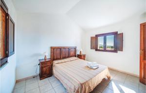ein Schlafzimmer mit einem Bett und einem Fenster in der Unterkunft Li Scalitti 2 in Badesi
