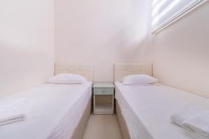 two twin beds in a room with a window at Apartments Near to City Center and Beach in Marmaris +10 photos