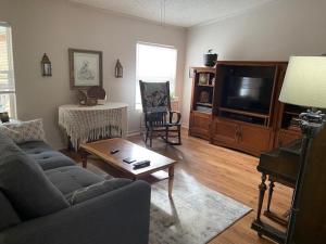 a living room with a couch and a tv at River Falls Lodging -Black Hills, South Dakota in Hot Springs